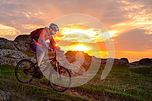 Cyclist Riding Mountain Bike on the Spring Rocky Trail at Beautiful Sunset. Extreme Sports and Adventure Concept.