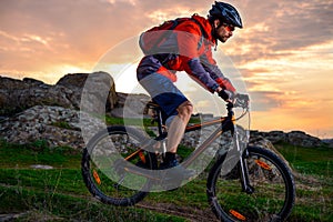 Cyclist Riding Mountain Bike on the Spring Rocky Trail at Beautiful Sunset. Extreme Sports and Adventure Concept.