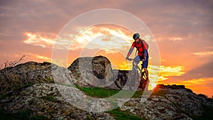 Cyclist Riding Mountain Bike on the Spring Rocky Trail at Beautiful Sunset. Extreme Sports and Adventure Concept. photo