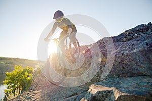 Cyclist Riding the Mountain Bike on the Summer Rocky Trail at the Evening. Extreme Sport and Enduro Cycling Concept.