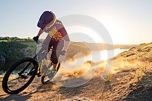 Cyclist Riding the Mountain Bike on the Summer Rocky Trail at the Evening. Extreme Sport and Enduro Cycling Concept.