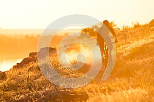 Cyclist Riding the Mountain Bike on the Summer Rocky Trail at the Evening. Extreme Sport and Enduro Cycling Concept.