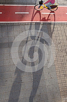 Cyclist riding on red urban bike lane in Las Palmas de Gran Canaria,bike shadow. .Urban bike lane concept