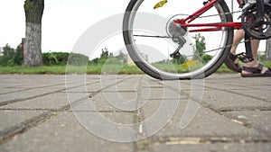 A cyclist rolls a bicycle with a flat, punctured wheel. Old Wheels Concept, problem