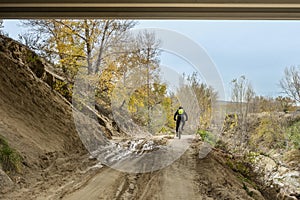 A cyclist on a route along a sandy and muddy track