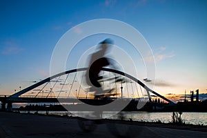 Cyclist Silhouette Next to Barqueta Bridge at Sunset in Sevilla, Spain photo