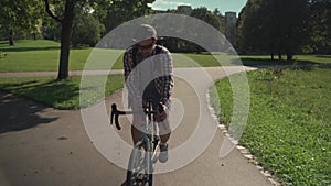 Cyclist uses smartphone application on handlebar of his bicycle to navigate while cycling in park in Germany. Man