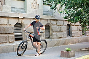 Cyclist walking old city street hurrying up for work
