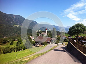 Cyclist on winding road in Alpe di Siusi, Italy