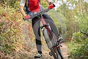 Cyclist woman legs riding mountain bike