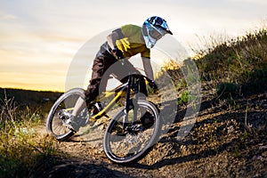 Cyclist in Yellow T-shirt and Helmet Riding Mountain Bike Down Rocky Hill. Extreme Sport Concept.