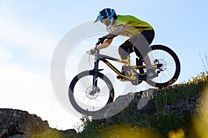 Cyclist in Yellow T-shirt and Helmet Riding Mountain Bike Down Rocky Hill. Extreme Sport Concept.