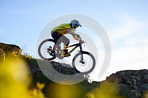 Cyclist in Yellow T-shirt and Helmet Riding Mountain Bike Down Rocky Hill. Extreme Sport Concept.