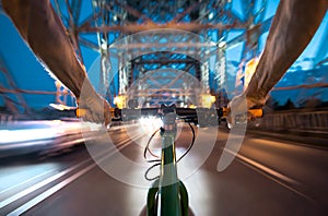 Cyclists ride at night over a bridge