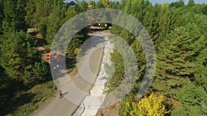 Cyclists turn off motorway heading towards lake onto forest path