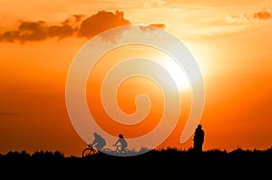 Cyclists and walkers at sunset photo