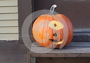 Cyclops Carved Pumpkin sits on a Door Step