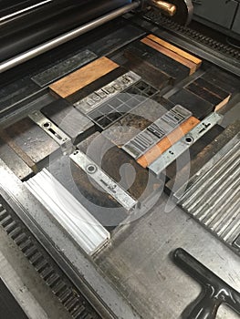Cylinder Press with Moveable, Metal Type Locked into a Chase photo