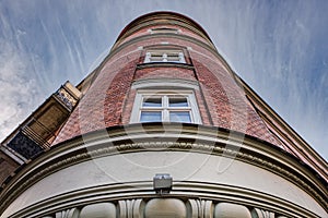 Cylindrical Classical or Neoclassical building facade made of bricks with windows in the middle features a red firebrick exterior