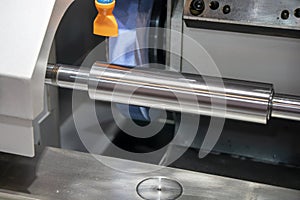 The cylindrical grinding machine make the surface finishing on the metal shaft control by CNC program. photo