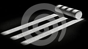 A cylindrical object with a textured surface casts a shadow on a black background.