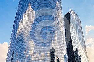 Cylindrical skyscraper with clouds reflected