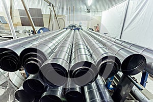 Cylindrical steel pipes. Round metal tubes in metalworking workshop