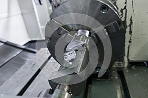 cylindrical workpiece clamped in 4-th axis of cnc milling machine after rough end milling operation
