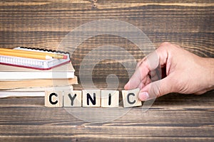 Cynic. Wooden letters on the office desk