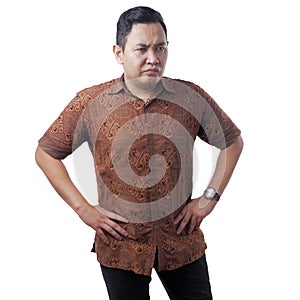 Cynical Asian man wearing batik shirt shows anger