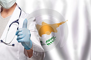 Cyprus doctor's hand showing thumb up positive gesture on flag of Cyprus background