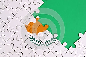 Cyprus flag is depicted on a completed jigsaw puzzle with free green copy space on the right side