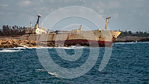 Cyprus, Paphos. Shipwreck. The ship crashed on the coastal rocks. Rusty ship at the shore of the Mediterranean sea. Tourist