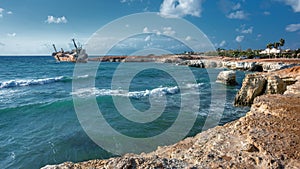 Cyprus, Paphos. Shipwreck. The ship crashed on the coastal rocks. Rusty ship at the shore of the Mediterranean sea. Tourist