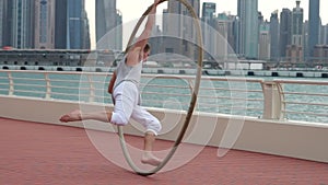 Cyr Wheel artist in slow motion with cityscape background of Dubai during sunrise
