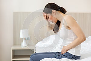 Cystitis in a woman. A young woman has a pain in the lower abdomen, she holds her stomach with her hand.