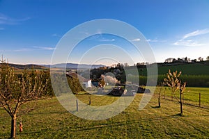 Czech farmhouse hidden in the middle of green fields with  landscape view  in the background