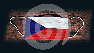 Czech Republic National Flag at medical, surgical, protection mask on black wooden background. Coronavirus Covidâ€“19, Prevent