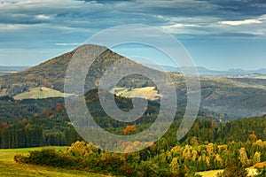 Czech typical autumn landscape. Hills and villages, fall forest. Morning fall valley of Bohemian Switzerland park. Hills with fog,