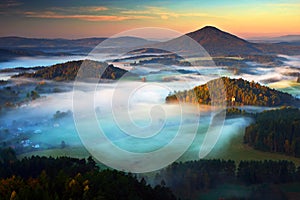 Czech typical autumn landscape. Hills and villages with foggy morning. Morning fall valley of Bohemian Switzerland park. Hills wit