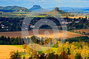 Czech typical autumn landscape. Hills and villages with sun. Morning fall valley of Bohemian Switzerland park. Hills with sun, lan