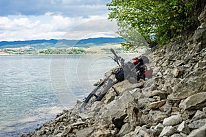 CZORSZTYN, POLAND - Jul 14, 2019: Bicycle with panniers on the rocky beach of Czorsztyn Lake