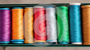 3D illustration of rows of colorful sewing threads on a white background