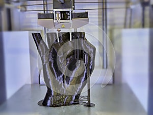 3D printer head moving to generate a black uman hand