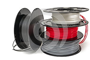 3D Printer Plastic Filament. Spools of black, red, grey, white thermoplastic wires  for 3d printing close up