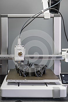 3D printer prints an object. The process of printing model on 3D printer. Model printed on 3D printer from molten