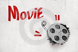 3d rendering of film tape breaking white wall with red `Movie` sign