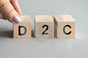 D2C word on wooden cubes, female hand holding one cube, Startup business concept and Direct Sales