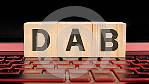 DAB written on wooden cubes on the laptop keyboard