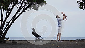 Dad with a baby on the beach with a stroller